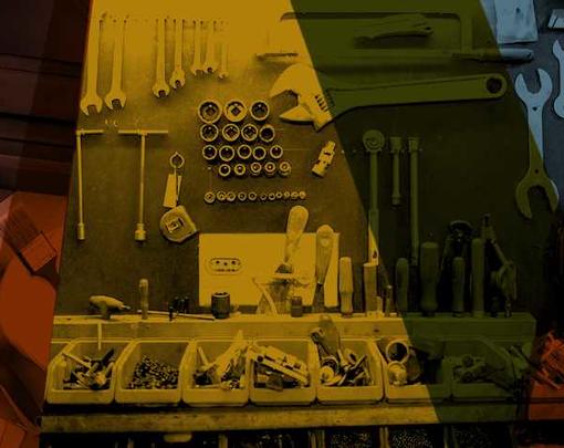 Tools are hung on a wall of a workshop with different colors overlapping over them.