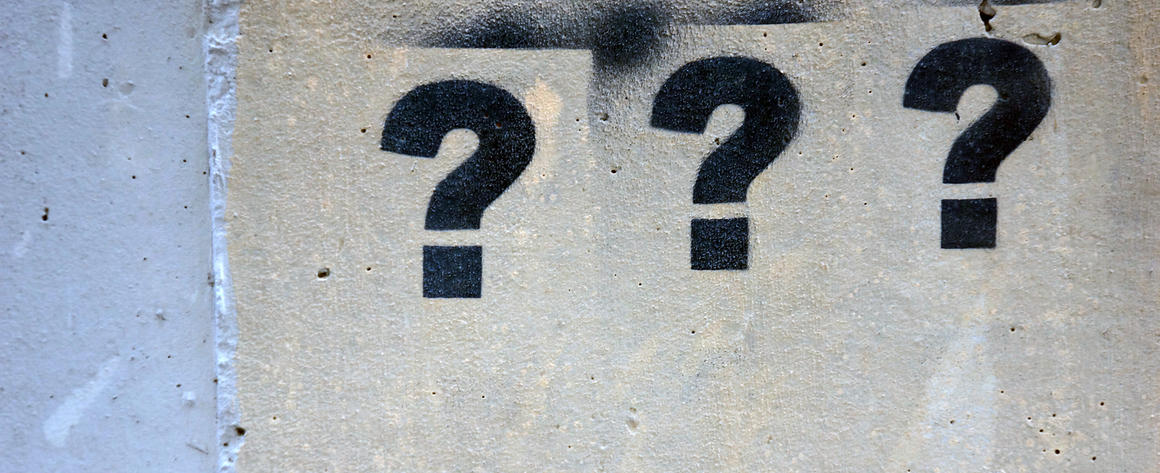 A series of question marks stenciled on a wall.