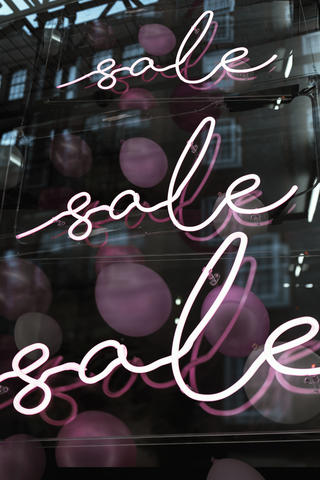 Neon window display proclaiming a sale