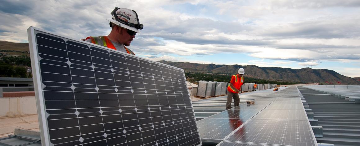 Men in hardhats installing solar panels