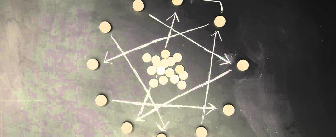 Money laid out on a chalkboard with arrows drawn around the coins.