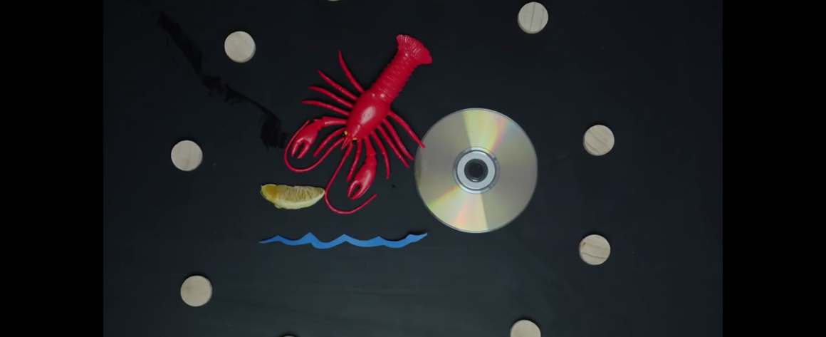 Abstract elements surrounding a lobster, a CD, and other signifiers of potential commons.