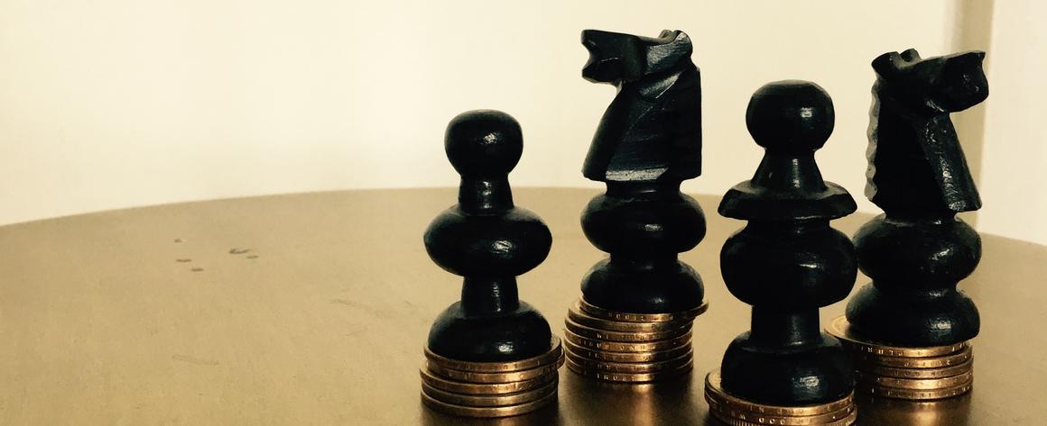 Various non-royalty chess pieces standing on roughly equal piles of coins
