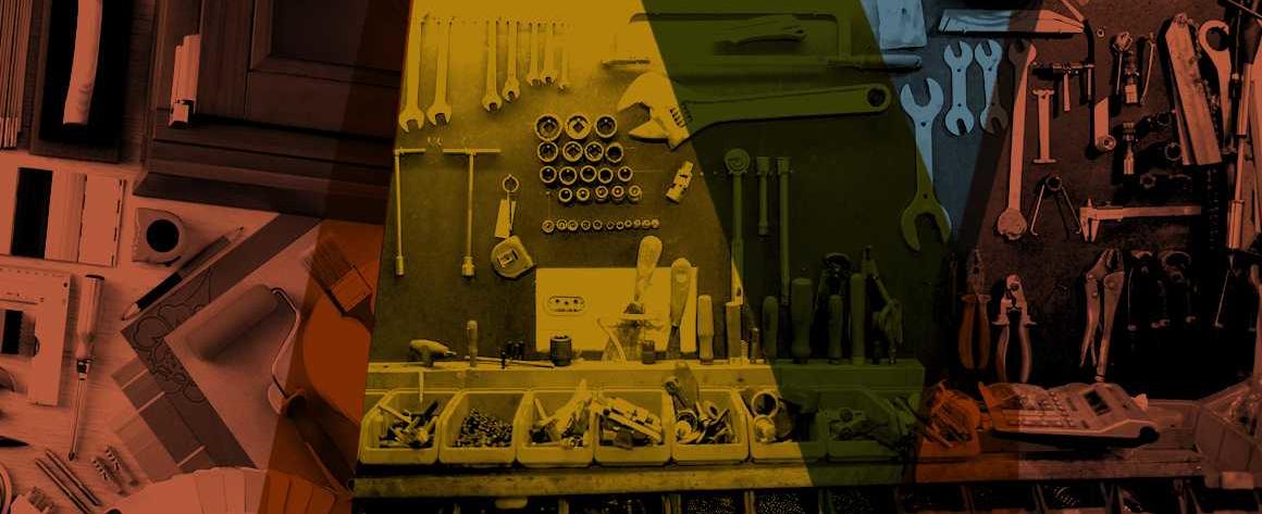 Tools are hung on a wall of a workshop with different colors overlapping over them.